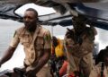 Nigerian Immigration Marine officers are seen on a boat going to Manga, a village that borders Nigeria and Cameroon, on January 28, 2022 weeks after suspected separatist fighters allegedly attacked Manga village in northeastern Nigeria, which left five people dead and 21 persons missing. – In the two neighbouring regions of western Cameroon, the army and separatists have been clashing for five years, squeezing the civilian populations. A forgotten crisis that killed more than 6,000 people and forced more than a million Cameroonians to flee their homes. But on November 17, 2021, around 50 armed separatists crossed the border into Nigeria and attcked the Manga village at dawn. Since the start of the conflict, more than 250 villages in western Cameroon have been destroyed, terrible revenge by separatists or Cameroonian soldiers against the populations accused of supporting one of the opposing camps. (Photo by Kola Sulaimon / AFP)