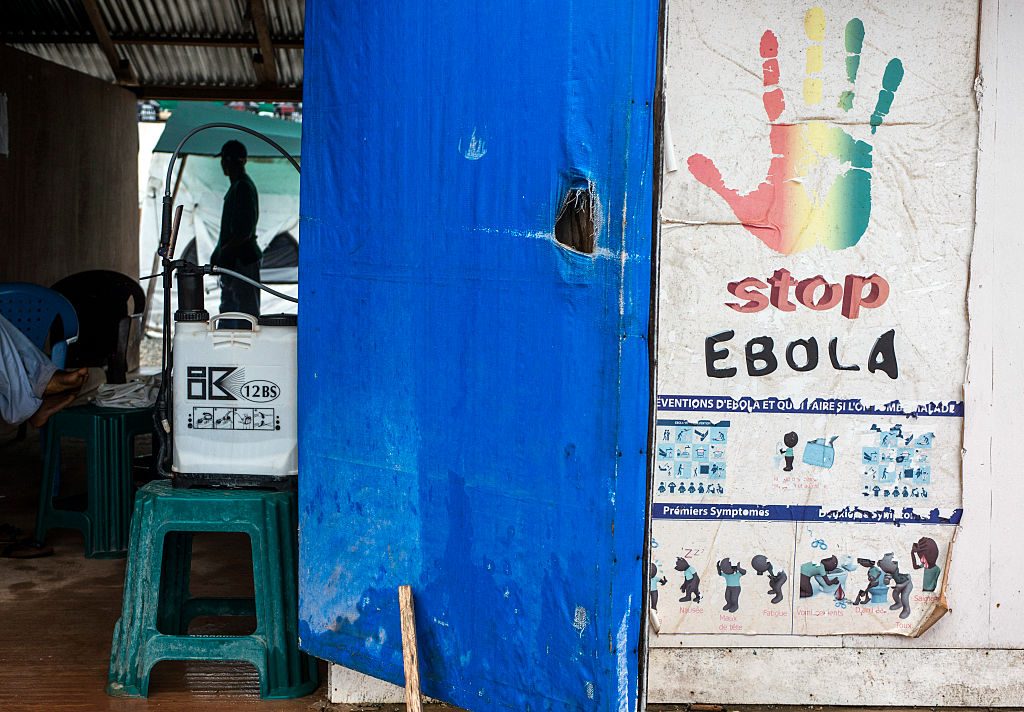 An ebola prevention poster sits outside an Ebola Treatment Center at Wankifong, Guinea, on Thursday, Sept. 10, 2015. An Ebola epidemic and a slump in commodity prices left the International Monetary Fund forecasting no economic growth this year. Photographer: Waldo Swiegers/Bloomberg via Getty Images