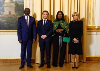 French President Emmanuel Macron (CL) poses alongside his wife Brigitte Macron (R), Liberia President Georges Weah (L) and Liberia President’s wife Clar Weah (CR) as they attend a dinner of the Paris Peace Forum at the Elysee Palace in Paris, on November 11, 2022. (Photo by GONZALO FUENTES / POOL / AFP)