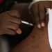 A man receives COVID-19 AstraZeneca vaccine during the flag-off of COVID-19 Mass Vaccination by the Nigerian government in Abuja, Nigeria, on November 19, 2021. (Photo by Kola Sulaimon / AFP)