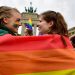 (FILES) In this file photo taken on June 30, 2017 two women are wrapped into a rainbow flag as they attend a rally of gays and lesbians in front of the Brandenburg Gate in Berlin. The same-sex partners of EU citizens have the right to live in any member state whatever their nationality, the bloc’s top court ruled on June 5, 2018, even in countries that do not recognise gay marriage. “Although the Member States have the freedom whether or not to authorise marriage between persons of the same sex, they may not obstruct the freedom of residence of an EU citizen by refusing to grant his same-sex spouse, a national of a country that is not an EU Member State, a derived right of residence in their territory,” the court said./ AFP PHOTO / Tobias SCHWARZ