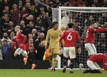 Manchester United’s Brazilian midfielder Antony (L) celebrates after scoring his team second goal during the UEFA Europa league knockout round play-off second leg football match between Manchester United and FC Barcelona at Old Trafford stadium in Manchester, north west England, on February 23, 2023. (Photo by Oli SCARFF / AFP)
