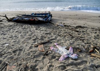 A photograph taken on February 28, 2023 shows a onesie and pieces of wodd washed up on the beach, two days after a boat of migrants sank off Italy’s southern Calabria region, in Steccato di Cutro, south of Crotone. – The overloaded wooden boat broke up and sank early on February 26, 2023 in stormy seas off Italy’s southern coast, with bodies, shoes and debris washing up along a long stretch of shoreline. The death toll rose on February 27, 2023 to 62 people, a coast guard official told AFP — and that number looked likely to increase. (Photo by Alessandro SERRANO / AFP)