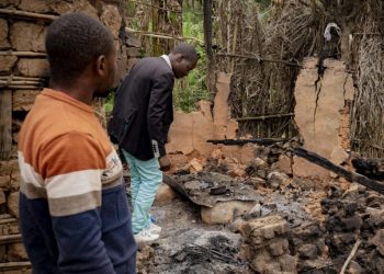 Deogratias Kasereka (R), the chief of the village of Mukondi, searches the remains of a house burned down during an attack attributed to the ADF in Mukondi, about 30 kilometers from the town of Beni, in eastern Democratic Republic of Congo, on March 10, 2023. – A village in eastern Democratic Republic of Congo lies almost deserted, haunted by the few survivors of an attack by the brutal fighters from the Allied Democratic Forces militia.They killed over 40 people in twin village attacks in eastern Democratic Republic of Congo this week. (Photo by Joel Bibuya / AFP)