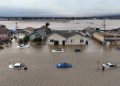 This aerial photograp shows cars and homes engulfed by floodwaters in Pajaro, California on Saturday, March 11, 2023. – Residents were forced to evacuate in the middle of the night after an atmospheric river surge broke the the Pajaro Levee and sent flood waters flowing into the community. (Photo by JOSH EDELSON / AFP)