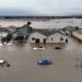 This aerial photograp shows cars and homes engulfed by floodwaters in Pajaro, California on Saturday, March 11, 2023. – Residents were forced to evacuate in the middle of the night after an atmospheric river surge broke the the Pajaro Levee and sent flood waters flowing into the community. (Photo by JOSH EDELSON / AFP)