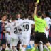 Spanish referee Ricardo De Burgos Bengoetxea shows a yellow card as players argue during the Spanish league football match between FC Barcelona and Real Madrid CF at the Camp Nou stadium in Barcelona on March 19, 2023. (Photo by LLUIS GENE / AFP)