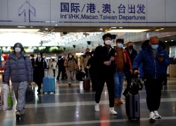 Travellers walk with their luggage at Beijing Capital International Airport, amid the coronavirus disease (COVID-19) outbreak in Beijing, China December 27, 2022. REUTERS/Tingshu Wang/File Photo