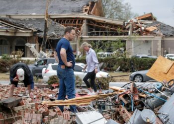 (FILES) In this file photo taken on March 31, 2023, Kris French (C) and his family search through rubble for a video recorder they think captured a direct tornado strike to their business, Champs Car Wash, after a tornado damaged hundreds of homes and buildings in Little Rock, Arkansas. – A major storm system bore down on the US east coast on April 1, 2023, after producing tornadoes and devastating winds across several central states that killed at least 11 people. Multiple tornadoes swept through Arkansas on March 31, 2023, including in the capital Little Rock, killing at least five people, the state’s governor said. Dozens of others have been reported injured. (Photo by Benjamin Krain / GETTY IMAGES NORTH AMERICA / AFP)
