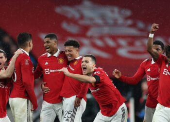 Manchester United’s Austrian midfielder Marcel Sabitzer (L), Manchester United’s Brazilian midfielder Casemiro (2L), Manchester United’s English striker Marcus Rashford (3L), Manchester United’s English striker Jadon Sancho (C), Manchester United’s Portuguese defender Diogo Dalot (3R) and Manchester United’s Brazilian midfielder Fred (R) celebrate after winning a penalty shoot out during the English FA Cup semi-final football match between Manchester United and Brighton and Hove Albion at Wembley Stadium in north west London on April 23, 2023. – Manchester United won after extra time and a penalty shoot out. (Photo by Adrian DENNIS / AFP) / NOT FOR MARKETING OR ADVERTISING USE / RESTRICTED TO EDITORIAL USE – NOT FOR MARKETING OR ADVERTISING USE / RESTRICTED TO EDITORIAL USE
