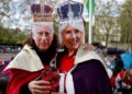 Royal fans wearing masks picturing Britain’s King Charles III (L) and Britain’s Camilla, Queen Consort (R) are pictured on The Mall, near to Buckingham Palace in central London, on May 5, 2023, ahead of the coronation weekend. – The country prepares for the coronation of Britain’s King Charles III and his wife Britain’s Camilla, Queen Consort on May 6, 2023. (Photo by Odd ANDERSEN / AFP)