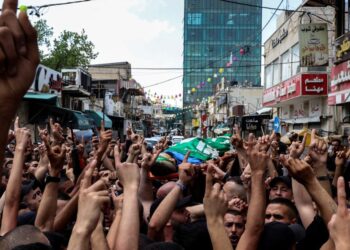 EDITORS NOTE: Graphic content / Mourners carry the body of one of two Palestinians killed by Israeli troops in a morning raid on Tulkarm in the occupied West Bank, during their funeral in the same city, on May 6, 2023. – The Israeli army claimed to have targeted the perpetrators of a May 2 “shooting attack” in the Avenei Heftz illegal settlement. (Photo by RONALDO SCHEMIDT / AFP)