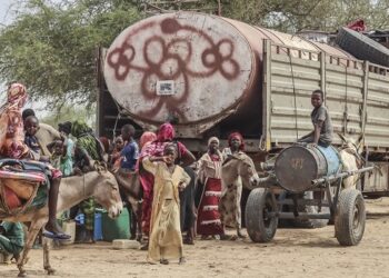 Sudanese refugees from the Tandelti area who crossed into Chad, in Koufroun, near Echbara, receive aid on April 30, 2023. (Photo by Gueipeur Denis SASSOU / AFP)