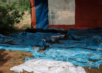 In this file photo taken on April 25, 2023, exhumed bodies in bodybags are displayed on the ground prior to a transport to the mortuary, at the mass-grave site in Shakahola, outside the coastal town of Malindi. (Photo by Yasuyoshi CHIBA / AFP) / NO USE AFTER JUNE 12, 2023 15:48:16 GMT