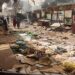 (FILES) People walk among scattered objects in the market of El Geneina, the capital of West Darfur, on April 29, 2023, as fighting continues in Sudan between the forces of two rival generals. – Sudan’s devastating war raged on into a third month on June 15, 2023, as the reported death toll topped 2,000 and after a state governor was killed in the remote Darfur region. (Photo by – / AFP)