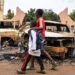 Children walk past burned cars outside the headquarters of president Bazoum’s Nigerien Party for Democracy and Socialism in Niamey on August 7, 2023. – Niger’s military rulers were on Monday in defiance of an ultimatum to restore the elected government as the threat of possible military intervention was still on the table. (Photo by – / AFP)
