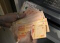 (FILES) A woman withdraws Argentine pesos from an ATM machine at a bank in Buenos Aires on November 4, 2021. – Argentine monetary authorities on August 14, 2023, devalued the peso by around 20 percent in anticipation of a market backlash to the strong performance of far-right politician Javier Milei in a presidential primary election. The Banco Nacion state bank showed the peso trading at 365.50 to the dollar, up from 298.50 on Friday. The libertarian Milei, a political outsider who has proposed dollarizing the country’s battered economy, performed much better than expected in the August 13 vote, in what local media referred to as a “political tsunami.” (Photo by Juan MABROMATA / AFP)