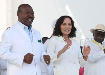 (FILES) Gabon President Ali Bongo Ondimba (L) and Gabon First Lady Sylvia Bongo Ondimba (C) are seen at the Nzang Ayong stadium in Libreville on July 10, 2023, a day after he announced that he would seek a third term as the oil-rich African nation’s head of state. – The wife of Gabon’s ousted president Ali Bongo Ondimba and two former ministers have been charged with “money laundering” and other offences, the public prosecutor said on September 29, 2023, a month after a coup toppled her husband. (Photo by Steeve JORDAN / AFP)
