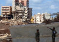 Soldiers stand in front of buildings destroyed in flash floods after the Mediterranean storm “Daniel” hit Libya’s eastern city of Derna, on September 14, 2023. – A global aid effort for Libya gathered pace on September 14 after a tsunami-sized flash flood killed at least 4,000 people, with thousands more missing, a death toll the UN blamed in part on the legacy of years of war and chaos. (Photo by Abdullah DOMA / AFP)