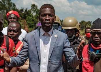 (FILES) Covered in dust, Ugandan musician-turned-politician Robert Kyagulanyi, also known as Bobi Wine, defied police roadblocks to stop him from entering towns in eastern Uganda and promised to walk to the nearest town, near Kayunga on December 1, 2020. - Ugandan opposition leader Bobi Wine was arrested on October 5, 2023 on his return home from a trip abroad, a top party official said.
"Our President (Bobi Wine) picked up by regime operatives as soon as he landed at the airport," David Lewis Rubongoya, the general secretary of Wine's National Unity Platform (NUP) said on X, formerly Twitter, with a photo appearing to show two men seizing him by the arms on the tarmac at Entebbe International Airport. (Photo by Sumy Sadurni / AFP)