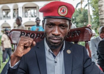 (FILES) Ugandan opposition leader Robert Kyagulanyi, also known as Bobi Wine, poses for a photograph after his press conference at his home in Magere, Uganda, on January 26, 2021. – Ugandan opposition leader Bobi Wine was arrested on October 5, 2023 on his return home from a trip abroad, a top party official said.“Our President (Bobi Wine) picked up by regime operatives as soon as he landed at the airport,” David Lewis Rubongoya, the general secretary of Wine’s National Unity Platform (NUP) said on X, formerly Twitter, with a photo appearing to show two men seizing him by the arms on the tarmac at Entebbe International Airport. (Photo by SUMY SADURNI / AFP)