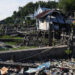 This photo taken on October 13, 2023, shows a person walking past debris on waterfront plots where houses once stood before Super Typhoon Haiyan struck in 2013, in Tacloban city, Leyte province. – The Philippines, which endures more than 20 major storms a year, has plenty of experience dealing with disasters. But that did not prepare them for one of the strongest typhoons on record. Haiyan unleashed winds of up to 315 kilometres (195 miles) an hour that flattened towns and cities across a 600-kilometre stretch of central islands. (Photo by Ted ALJIBE / AFP) /