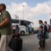 People prepare to board a bus as dual national Palestinians and foreigners get ready to cross the Rafah border point with Egypt, in the southern Gaza Strip. Egypt will help evacuate “about 7,000” foreigners and dual nationals from the war-ravaged Gaza Strip, the foreign ministry said, with officials saying some 400 people were expected to cross on November 2. (Photo by Mohammed ABED / AFP)