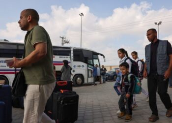 People prepare to board a bus as dual national Palestinians and foreigners get ready to cross the Rafah border point with Egypt, in the southern Gaza Strip, on November 2, 2023. – Egypt will help evacuate “about 7,000” foreigners and dual nationals from the war-ravaged Gaza Strip, the foreign ministry said, with officials saying some 400 people were expected to cross on November 2. (Photo by Mohammed ABED / AFP)