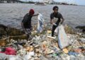 (FILES) Residents collect plastics bottles and bags in the Ebrie Lagoon in Abidjan on May 31, 2023 ahead of World environnement Day celebrations. – The latest negotiations towards a global treaty to combat plastic pollution open in Nairobi on November 13, 2023 with tensions expected as nations tussle over what should be included in the pact.Some 175 countries agreed last year to conclude by 2024 a UN treaty to combat the plastic blighting oceans, floating in the atmosphere and infiltrating the bodies of animals and humans. (Photo by Issouf SANOGO / AFP)