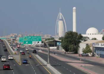 Traffic flows past Dubai’s Gargash mosque (R) and its landmark Burj al-Arab (C) luxury hotel on December 10, 2023. – The United Arab Emirates suffers from high air pollution levels fed by its fossil fuel industry, Human Rights Watch warned earlier this month, as the oil-rich country hosts the UN’s COP28 climate talks in Dubai. (Photo by Giuseppe CACACE / AFP)