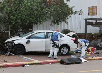 Israeli police forensics personnel inspect a damaged car following a suspected ramming attack in the central town of Raanana, on January 15, 2024. (Photo by JACK GUEZ / AFP)