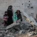 Palestinians walk amid the rubble of damaged buildings following Israeli bombardment in Rafah, on the southern Gaza Strip on February 12, 2024, amid ongoing battles between Israel and the militant roup Hamas. – Israel announced on February 12 the rescue of two hostages in the southern Gaza city of Rafah, where the Hamas-run health ministry said “around 100” Palestinians including children were killed in heavy overnight air strikes. (Photo by SAID KHATIB / AFP)