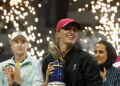 Iga Swiatek of Poland lifts the trophy after winning against Elena Rybakina of Kazakhstan (L) during their women’s singles final match at the Qatar Open tennis tournament in Doha, during a podium ceremony attended by Sheikha Al-Mayassa bint Hamad bin Khalifa Al Thani (R), sister of Qatar’s ruling Emir on February 17, 2024. (Photo by KARIM JAAFAR / AFP)